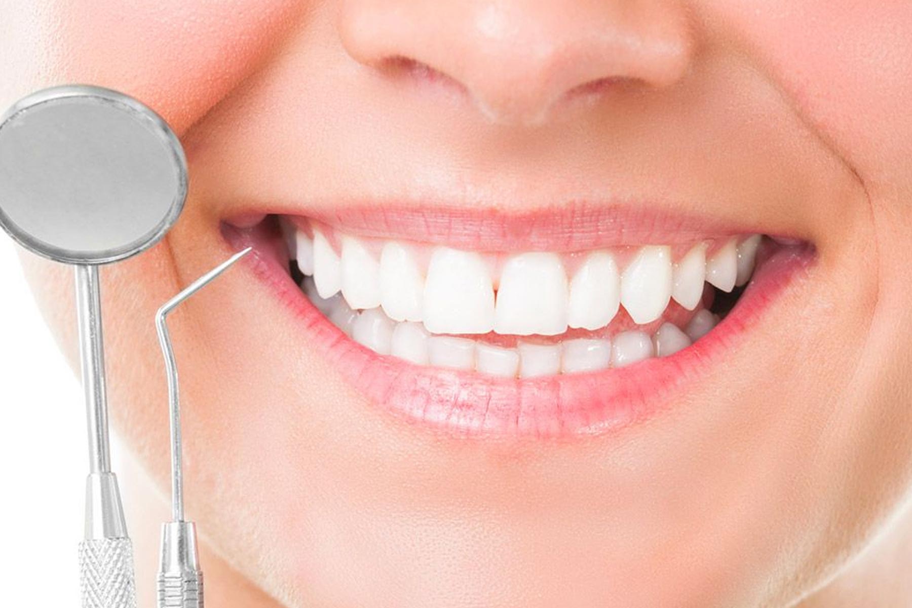 Close up picture of smiling mouth with oral hygiene instruments used by dentist