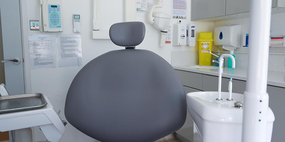 Sarum Dental Practice treatment room with close up of grey dental chair and rinsing sink